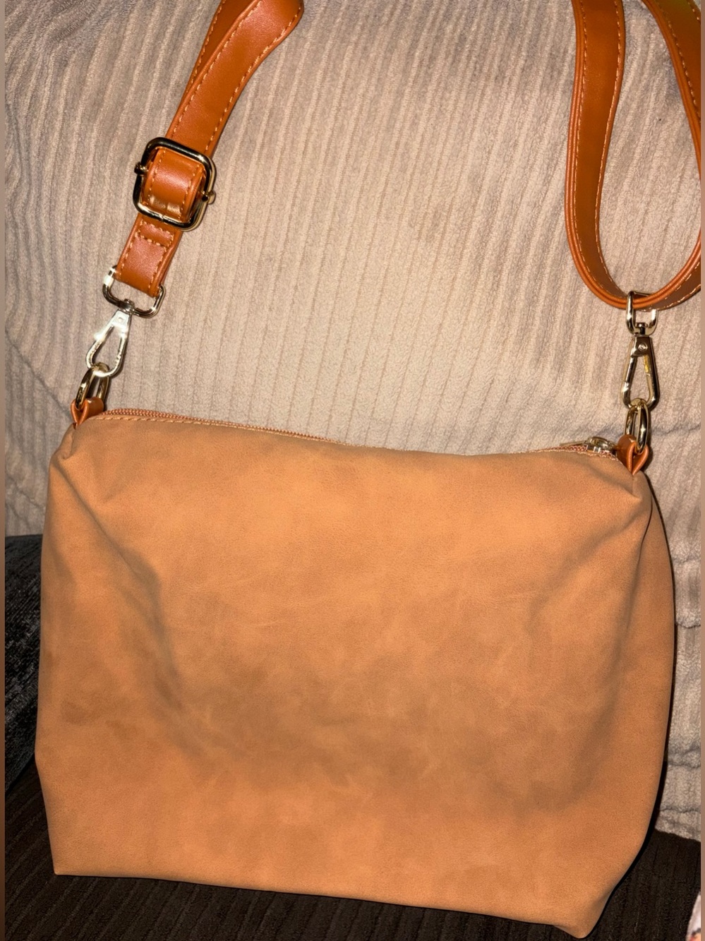 New without tags, small tan suede-like bag with gold hardware.